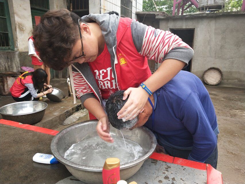 图为志愿者为老人洗头